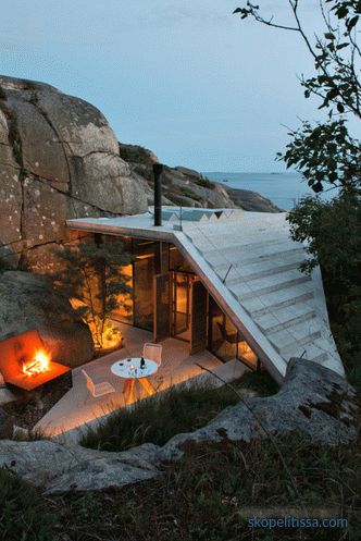 Casa con pareti trasparenti sulle rive rocciose soleggiate in Sandefjord, Norvegia
